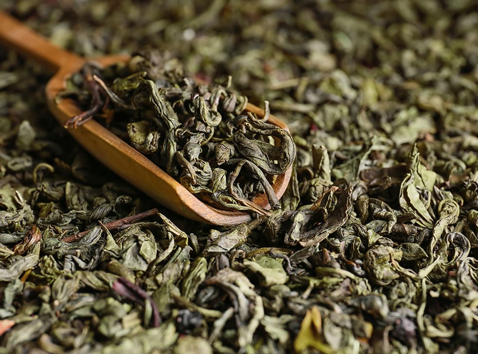 Scoop on dry green tea leaves, closeup